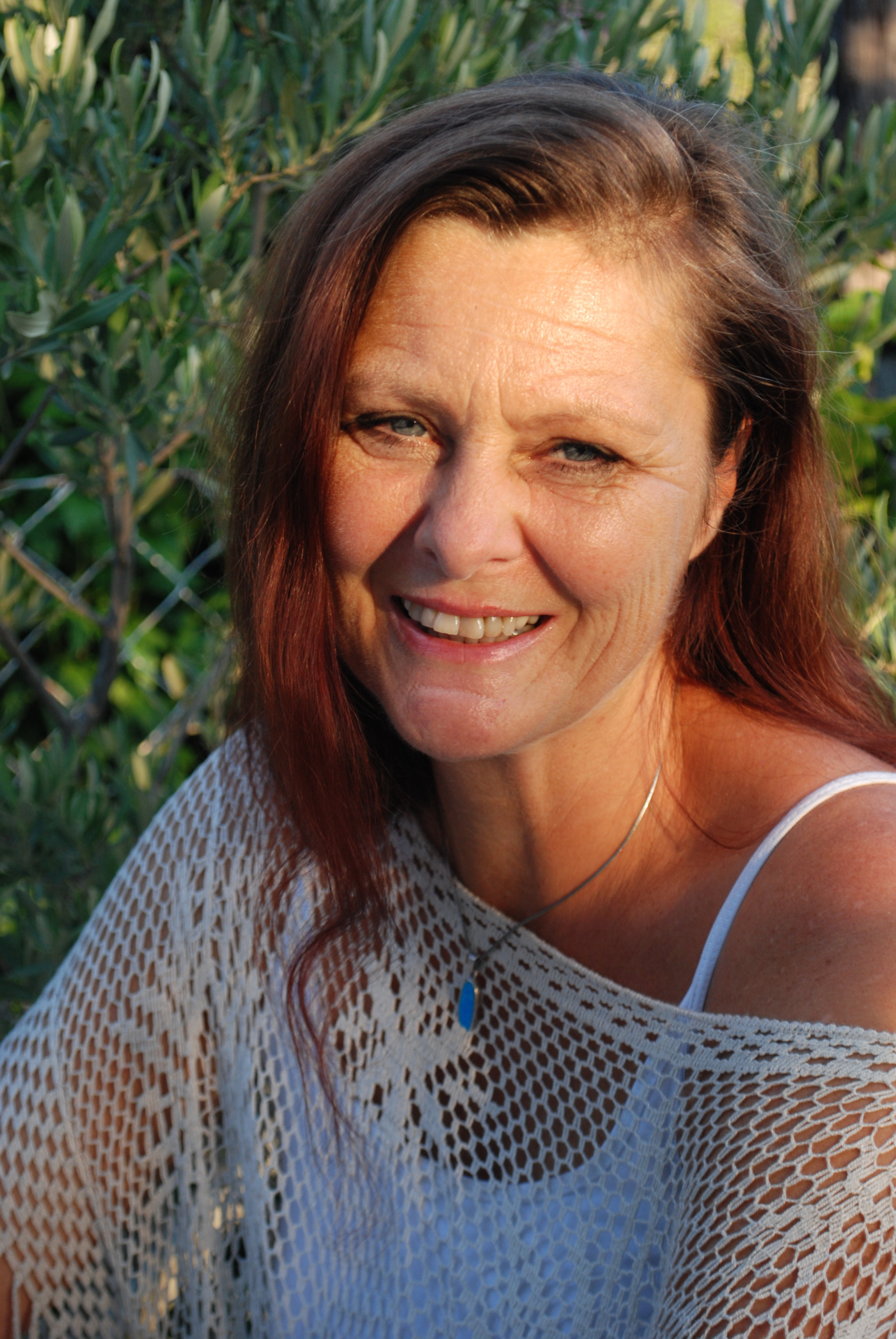 Ein Portrait von mir, wie ich freundlich in die Kamera lächle.